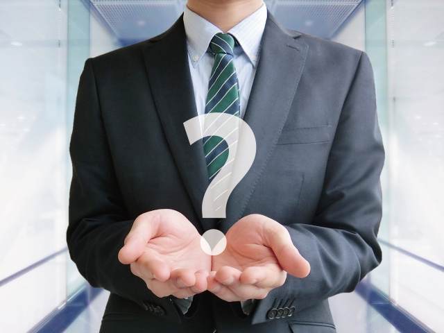 はてなマークを持つ男性