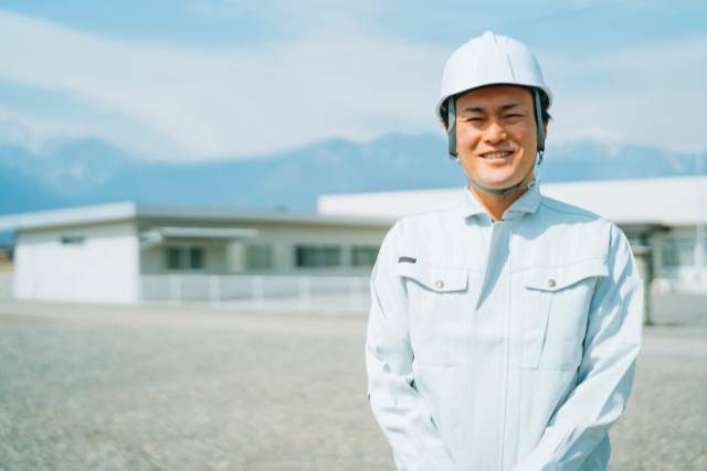 屋外に立っている作業服の男性